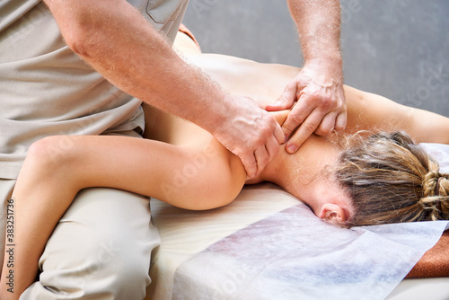 male masseur doing neck massage to woman