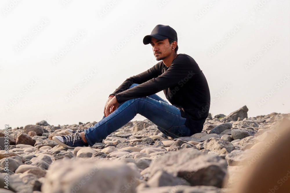 Young indian man standing on rocks