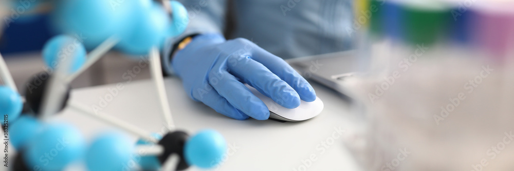 Workplace scientist with gloves working on laptop. Scientific research and development of new drugs concept