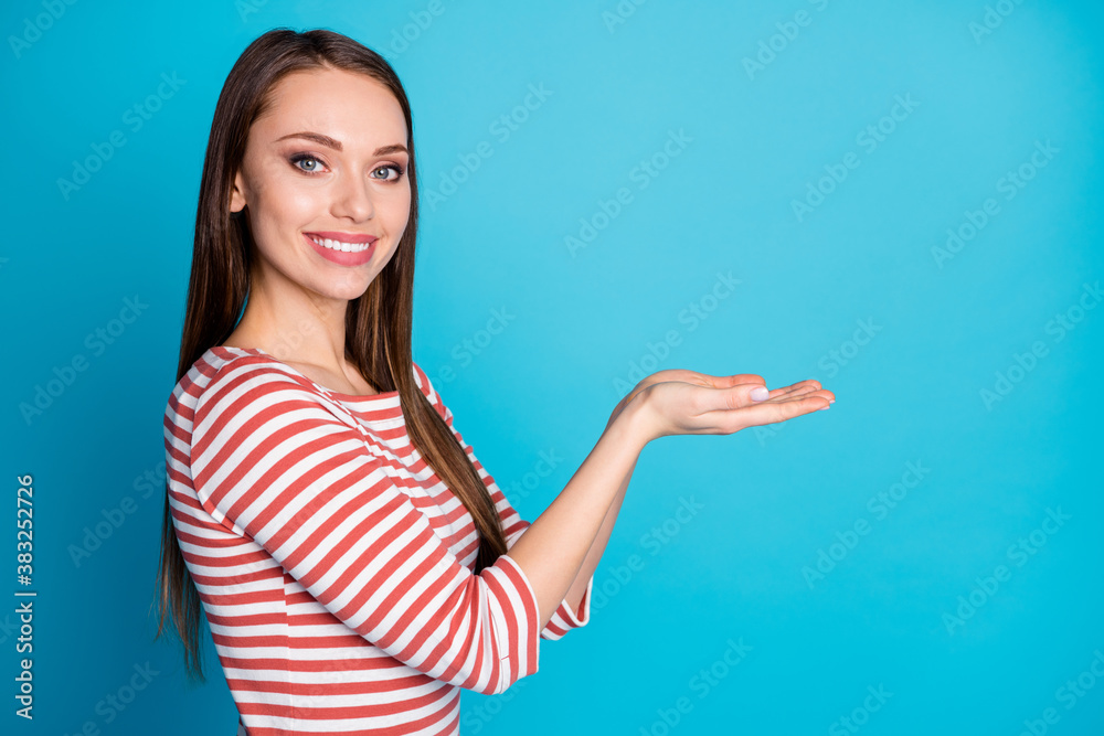 Fototapeta premium Profile side photo of content girl promoter hold hand demonstrate object promotion advert wear casual style shirt isolated over blue color background