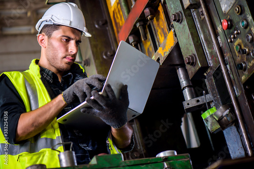 Obraz na płótnie Caucasian engineer mechanic man checking for maintenance pressing metal machine
