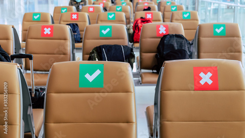 Social distancing  Rows of empty chairs in an airport s departure area marked with symbols regarding social distancing protocol to prevent the spreading of novel corona virus  COVID-19 in Thailand