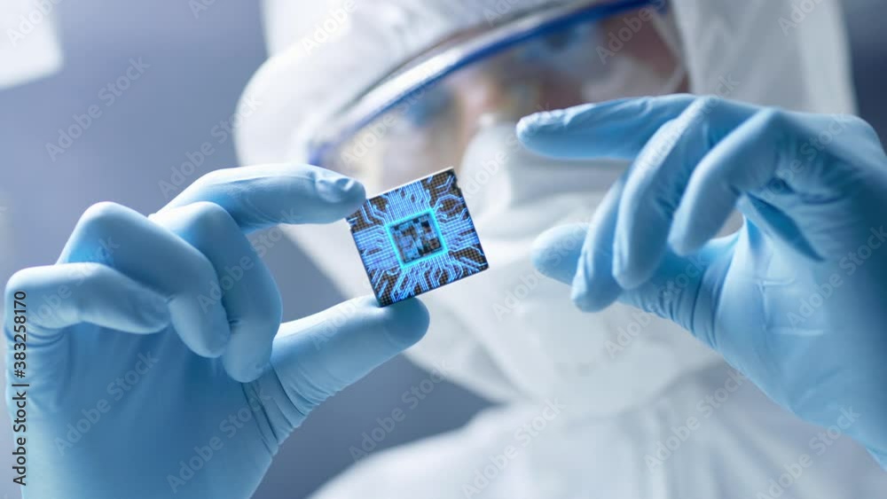 Futuristic Technology Concept: Engineer in Sterile Coverall Holds Computer Microchip with Gloves and Examines it. CPU Processor Digitalization with Data Lines Form Artificial Intelligence Symbol