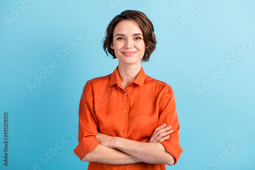 Photo of attractive charming lady cute bobbed hairdo arms crossed self-confident person worker friendly smile good mood wear orange office shirt isolated blue color background photo