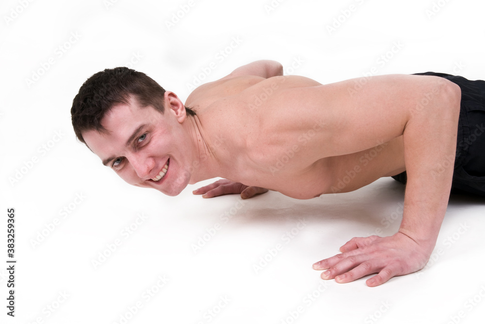 Man with a naked torso doing push-ups on a white background Man with a naked torso doing push-ups on a white background
