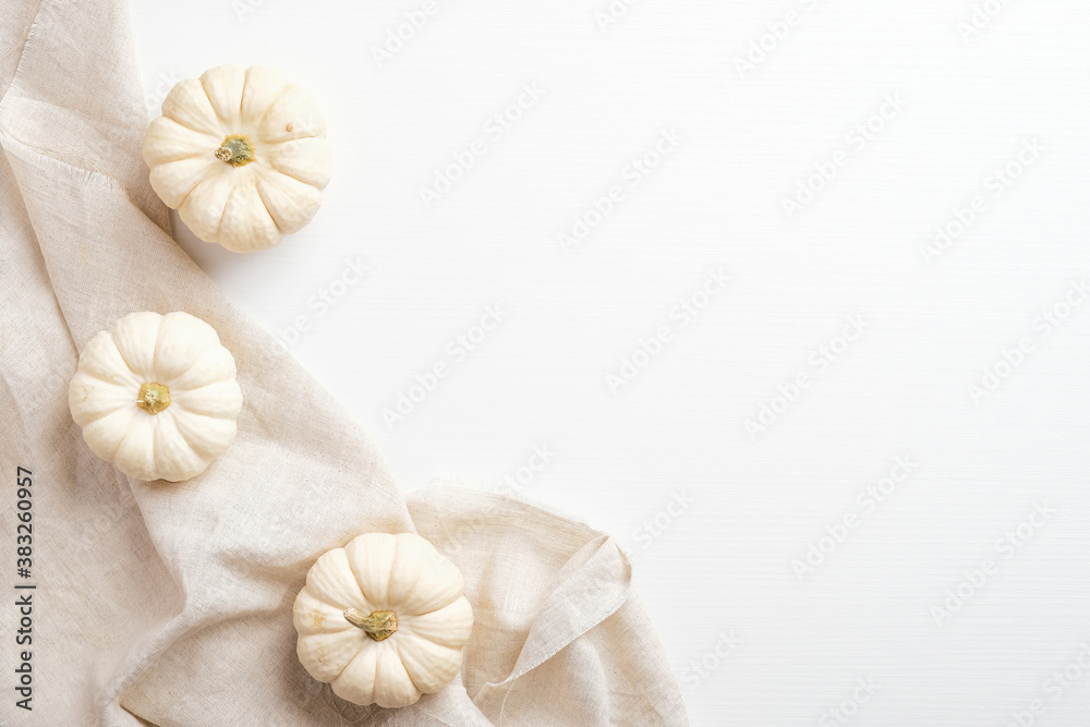 Autumn composition. White desk table with pumpkins decoration and with beige fabric. Flat lay, top view. Nordic, hygge, cozy home concept Autumn composition. White desk table with pumpkins decoration and with beige fabric. Flat lay, top view. Nordic, hygge, cozy home concept
