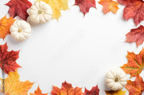 Autumn leaves and pumpkins border frame on white table. Seasonal background. Autumn fall, thanksgiving, harvest concept. Flat lay, top view.