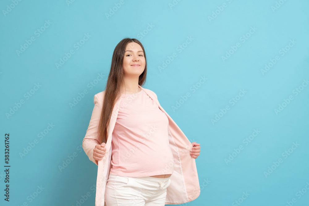 funny young pregnant woman in pink t-shirt on blue background, woman cannot wear clothes, small clothes funny young pregnant woman in pink t-shirt on blue background, woman cannot wear clothes, small clothes