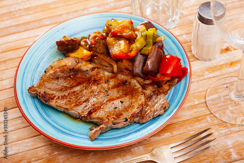 Appetizing beef entrecote with baked vegetables served at plate