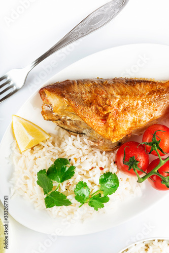 Sea bass grill with rice, greenery and cherry tomatoes. White background.