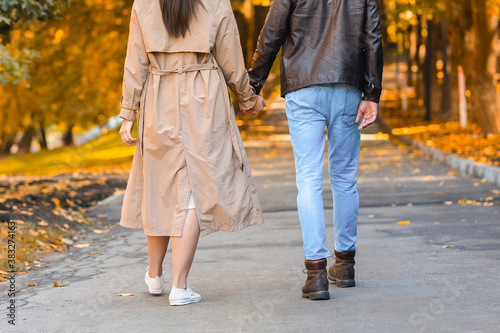 Cropped image of two lovers holding hands and walking