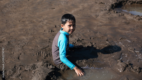 Asian kid play sand on beach