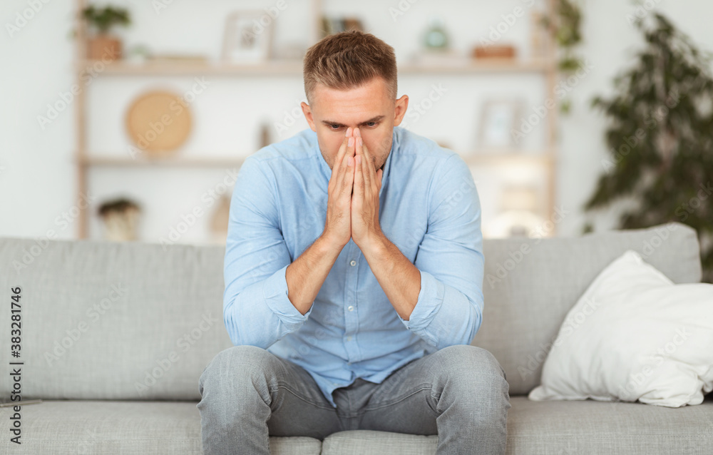 Depressed sad man sitting on couch, thinking about problems Depressed sad man sitting on couch, thinking about problems
