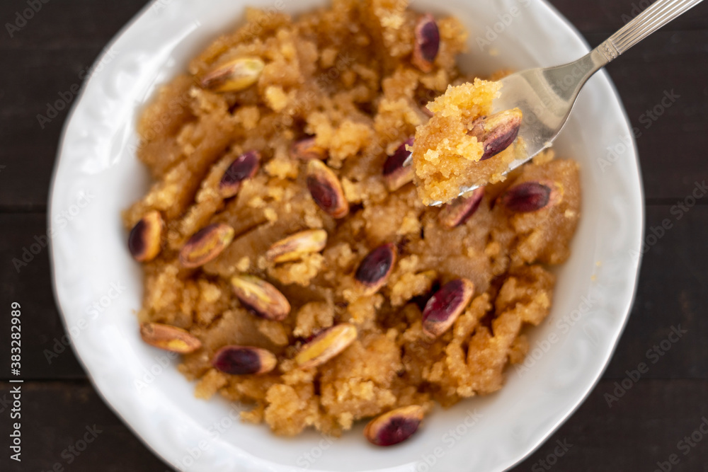 semolina halva. Turkish dessert; irmik helvası with pistachio on wooden background semolina halva. Turkish dessert; irmik helvası with pistachio on wooden background