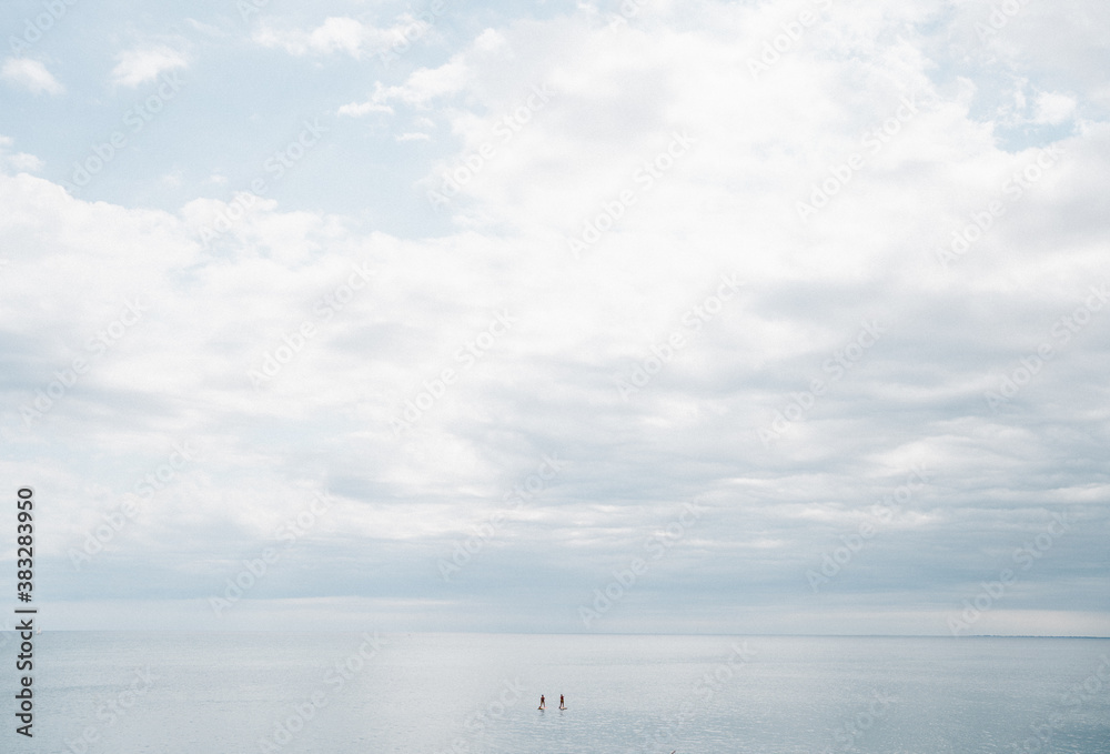 Paddle surf en el océano: pareja de paddle surfers en el mar en un día de sol y nubes