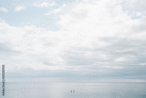 Paddle surf en el océano: pareja de paddle surfers en el mar en un día de sol y nubes