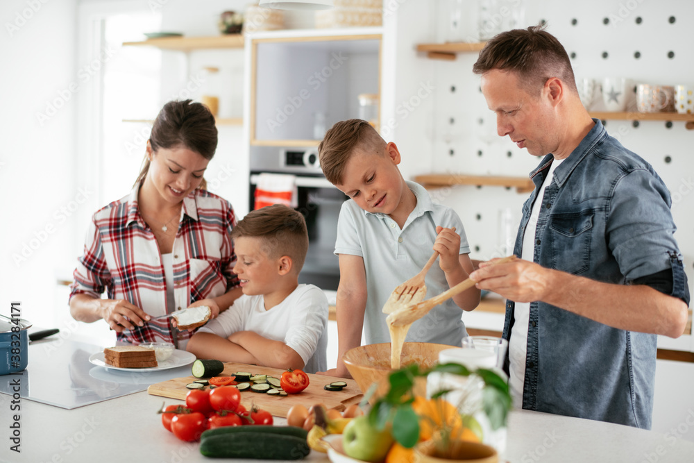 Mother and father making breakfast with sons. Young family preparing delicious food in kitchen... Mother and father making breakfast with sons. Young family preparing delicious food in kitchen...
