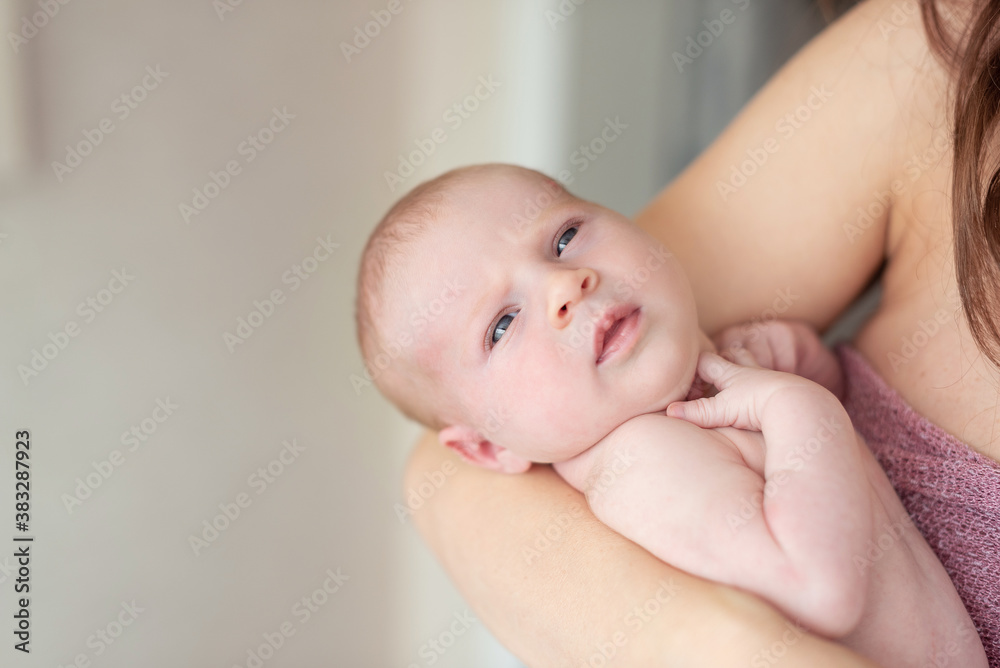 A newborn baby lies in the arms of the mother. Breastfeeding concept. A newborn baby lies in the arms of the mother. Breastfeeding concept.