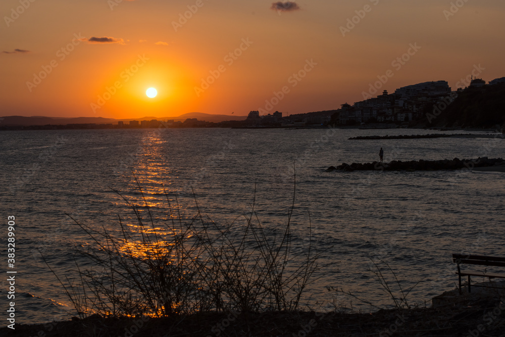 Naklejka premium The sun at sunset reflected in the sea water