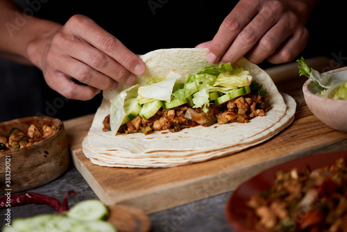 man preparing a durum or a burrito photo