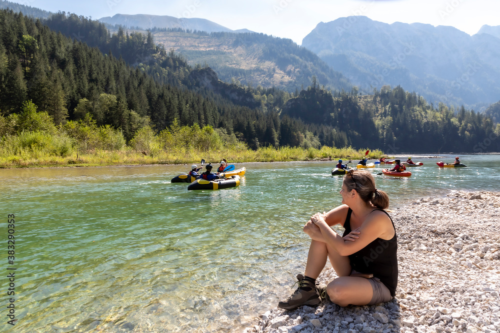 woman watching kayaker on river Salza near Wildalpen in Styria, Austria