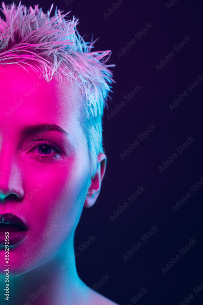 Sensual. Portrait of female fashion model in neon light on dark studio background. Beautiful caucasian woman with trendy make-up and well-kept skin. Vivid style, beauty concept. Close up. Copyspace Sensual. Portrait of female fashion model in neon light on dark studio background. Beautiful caucasian woman with trendy make-up and well-kept skin. Vivid style, beauty concept. Close up. Copyspace