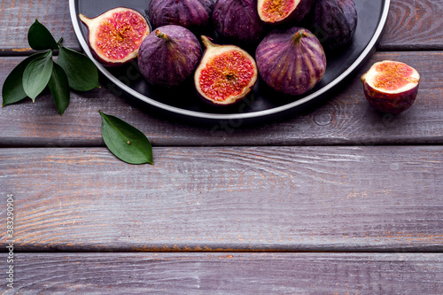 Fresh ripe figs in on plate with leaves. Mediterranean fruit background