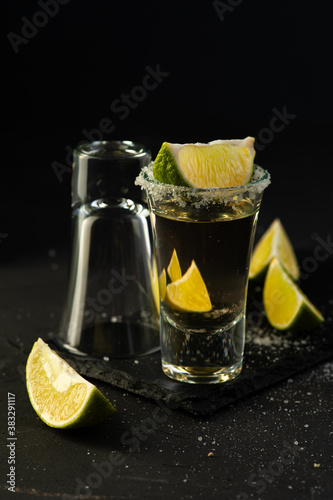 Mexican Tequila Gold in glasses with lime slices and salt.