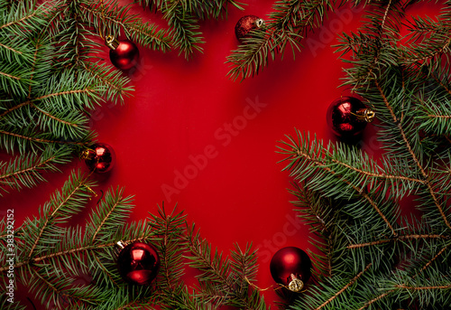 Christmas composition on a red background with fir branches  toys  copy space for your congratulations