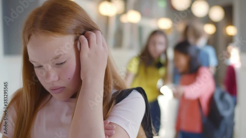 Teen schoolgirl being bullied by group of students in high school