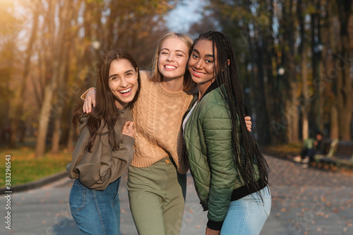 Trio of pretty teen girls posing in public park photo
