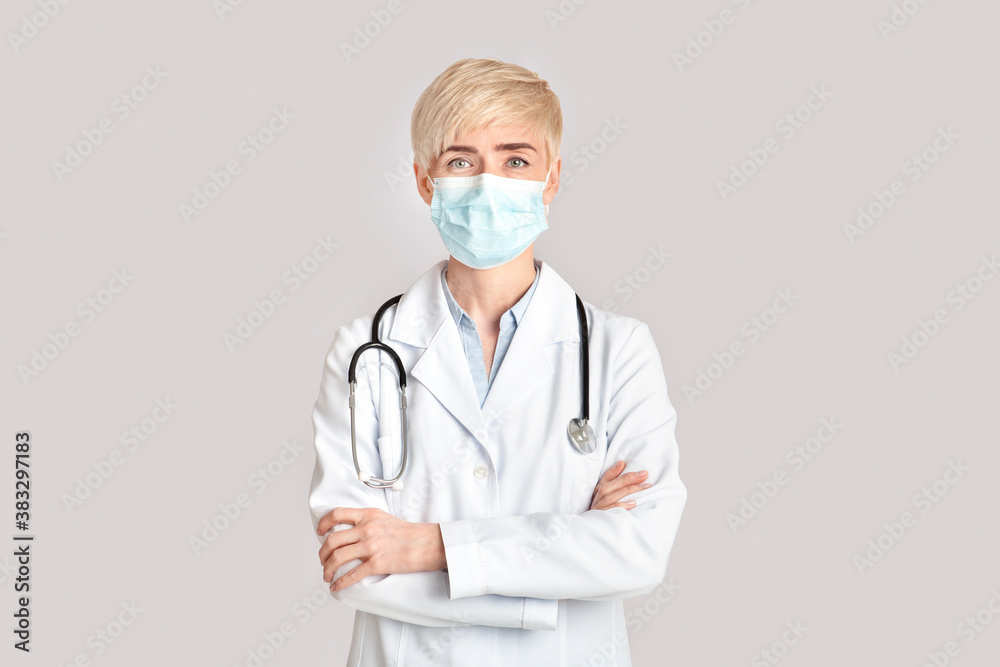 Quarantine, health protection and treatment. Blonde mature woman doctor in surgical protective mask against infection Quarantine, health protection and treatment. Blonde mature woman doctor in surgical protective mask against infection