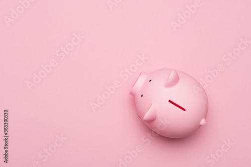 Pink piggybank seen from a high anlge view on a pink background as concept for financial issues