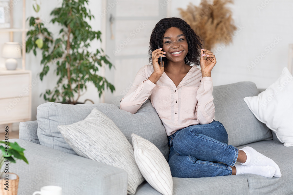 Joyful African Lady Having Phone Call While Relaxing On Couch At Home Joyful African Lady Having Phone Call While Relaxing On Couch At Home