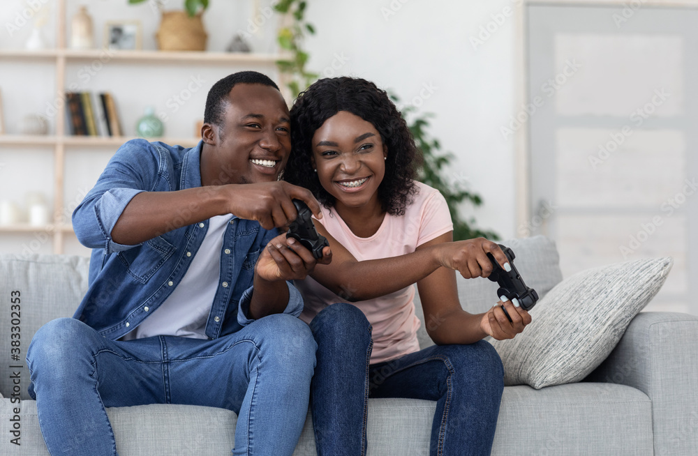 Joyful african american couple with joysticks at home Joyful african american couple with joysticks at home