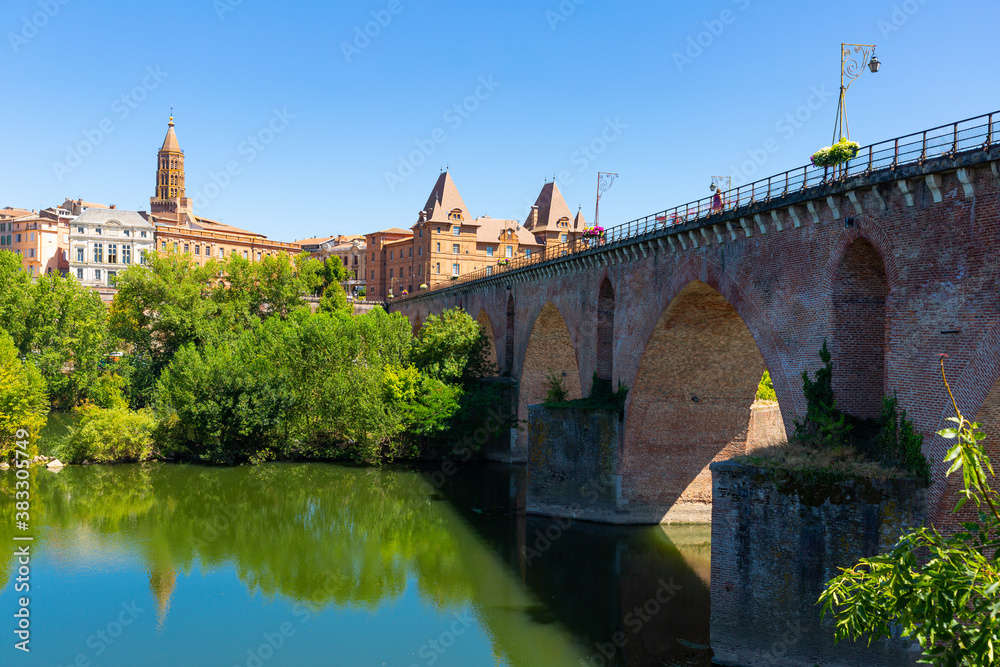 Medieval bridge over the Tarn river in Montauban city on sunny day. France
