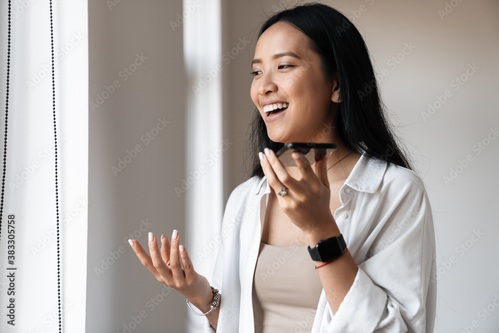 Photo of beautiful happy asian smiling while talking on mobile phone Photo of beautiful happy asian smiling while talking on mobile phone