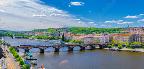 Aerial panoramic view of Prague city historical center with Smichov district, Palackeho most bridge, row of buildings along Vltava river, blue sky white clouds background, Bohemia, Czech Republic photo