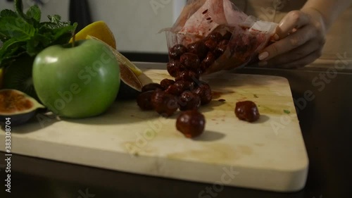 Woman drop the pack of cherry on the table