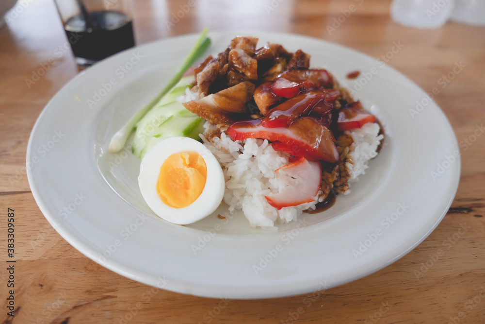 Thai dish of BBQ pork and crispy belly pork on rice with barbecue red sauce