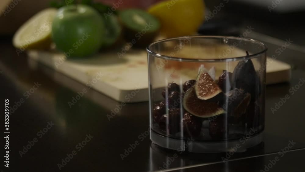 Woman drop figs in the mixer bowl Woman drop figs in the mixer bowl