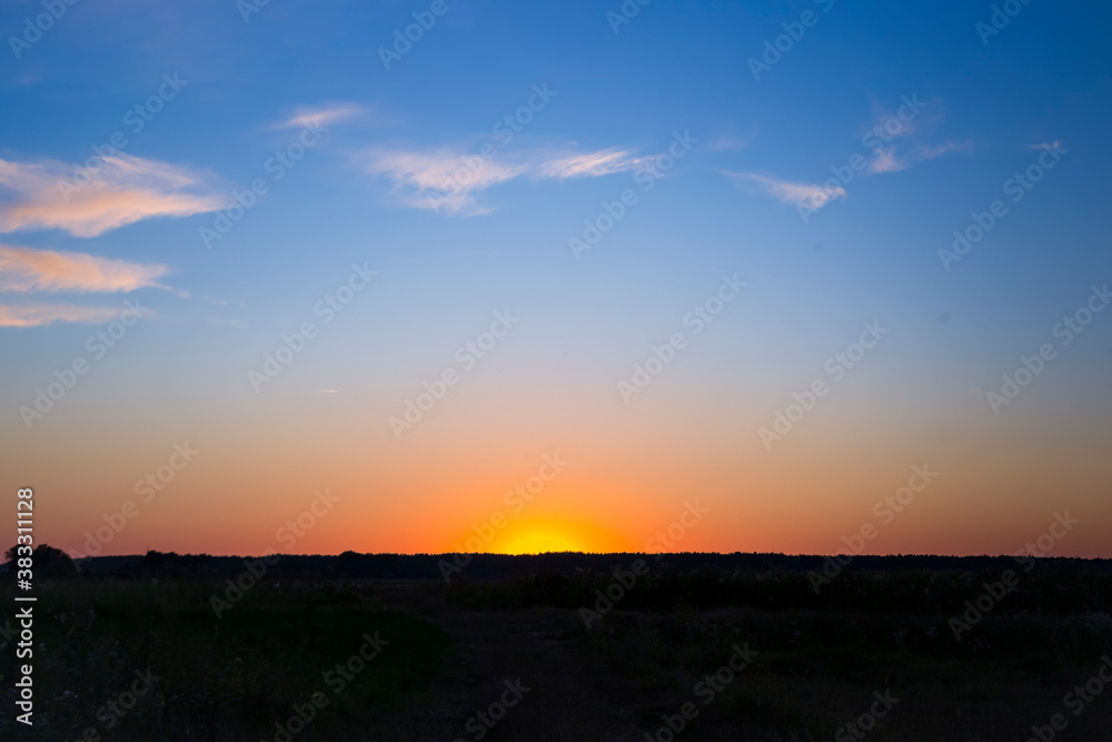 Orange sun set over forest horizon and blu sky Orange sun set over forest horizon and blu sky