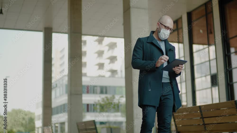 Man Stand Outside in Face Mask With Tablet .