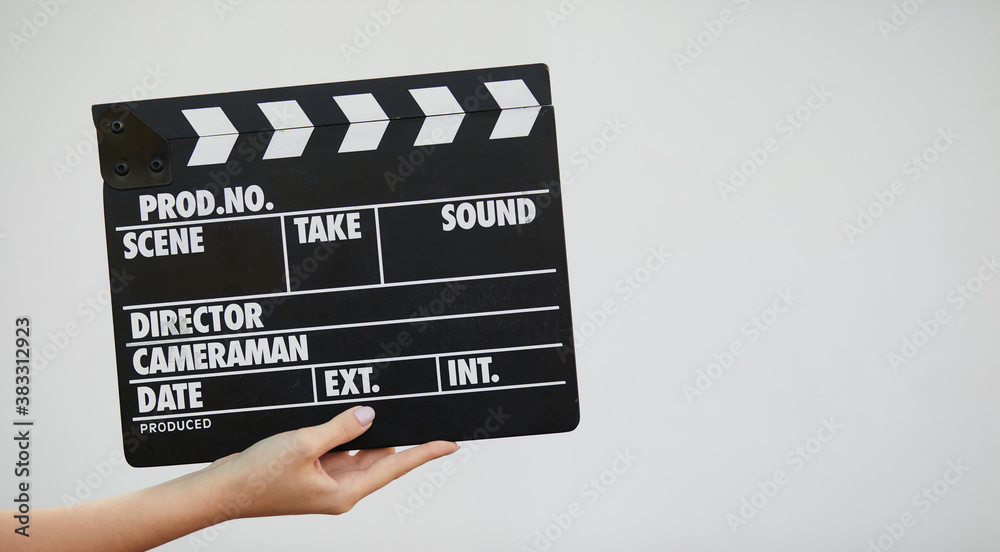 Close up view of female hands holding movie clapperboard on white background.