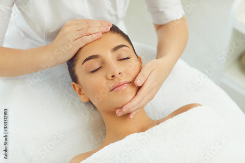 Close-up of serene woman getting procedure of relaxing manual facial massage from masseur