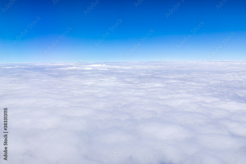 Clouds and sky as seen through window of an aircraft.