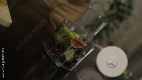 Mixer bowl with fruits on the table
