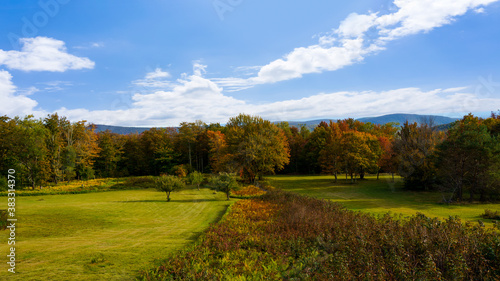 Landscape of Catskills mountain in New York with colorful trees, green land and blue sky