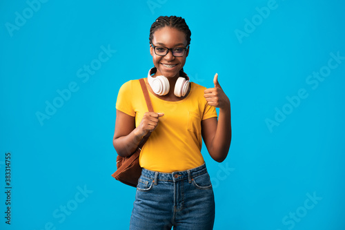 African Female Student Gesturing Thumbs Up Posing Over Blue Background