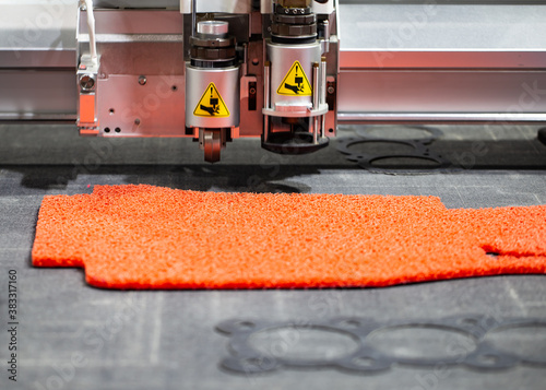 CNC laser cutting machine cutting car carpet mat and engine gasket. Industrial manufacturing